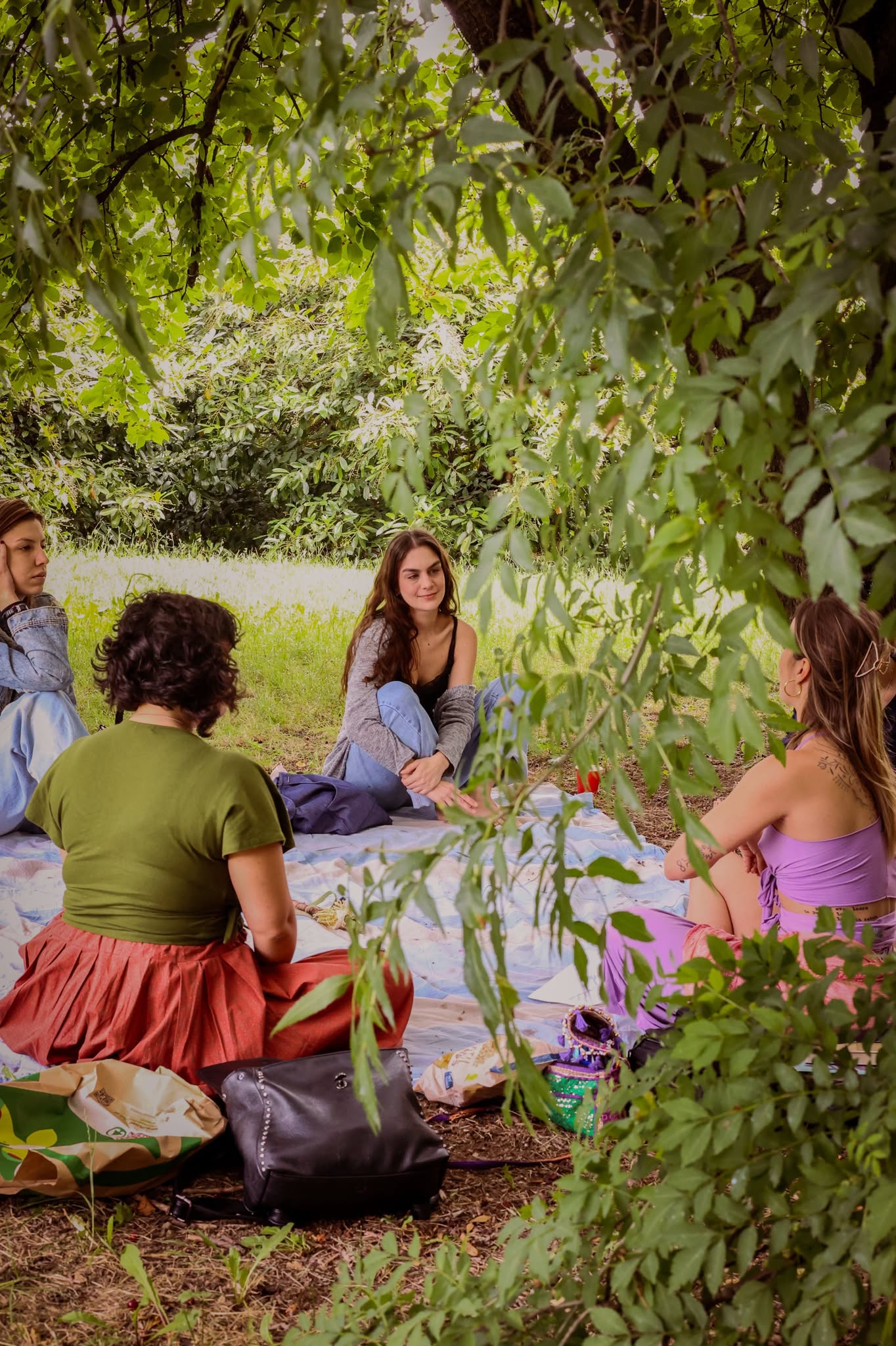 Un gruppo in cerchio attorno a un tavolo in giardino, immerso nel verde